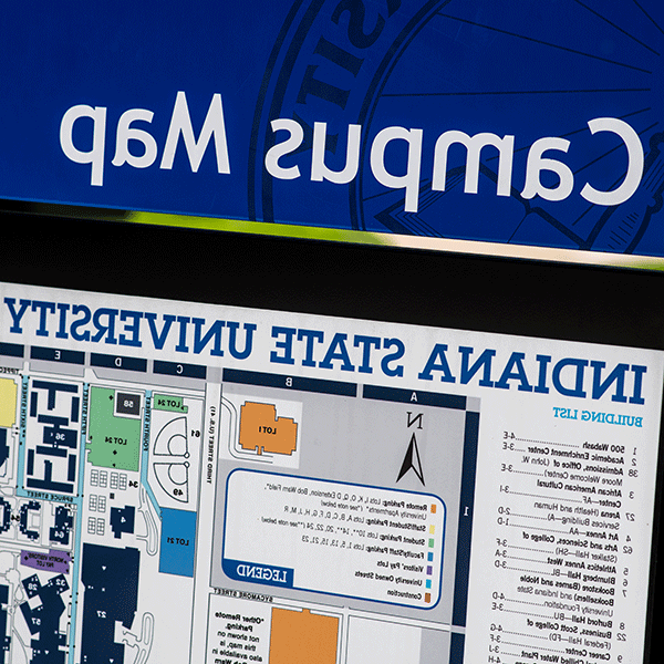 Campus map signage. The top of the sign reads “Campus Map” in white letters on blue background. Beneath that is visible a graphic sign with key text. The sign reads “Indiana State University” at the top.